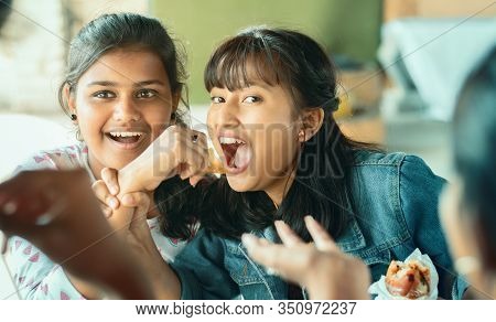 Teenager Trying To Take Or Grab Food From Friend - Young Girl Playfully Fighting For Snacks With Her