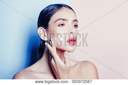 Attractive Girl Putting Anti-aging Cream On Her Face. Closeup Portrait Of Girl With Healthy Smooth S