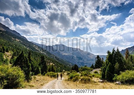 Turkey, Chamard - August 3, 2019: Tourists Walk Along The Road Through The Mountain Landscape In The