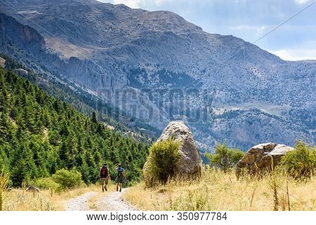 Turkey, Chamard - August 3, 2019: Tourists Walk Along The Road Through The Mountain Landscape In The