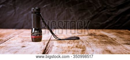 Small Pocket Led Torch Isolated On Wooden Table