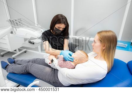 Mom And Baby At The Reception At The Pediatric Dentist. First Visit To The Dentist. Diagnosis And Tr