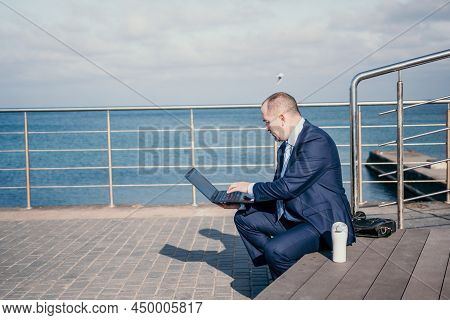 Confident Middle Age Businessman Working Remotely Online, Typing On A Laptop Keyboard While Sitting 