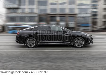 Black Kia K5 Car In Motion With Urban Blurred Background. Moscow, Russia - February 2022