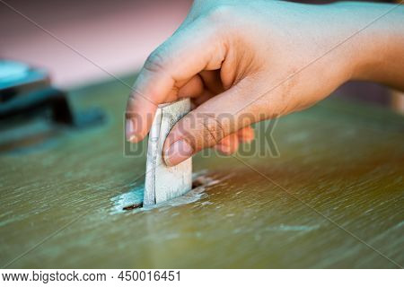 Person Are Making Merit. Woman Hand Is Dropping Twenty Baht Banknotes Of Thailand Into Wooden Cabine