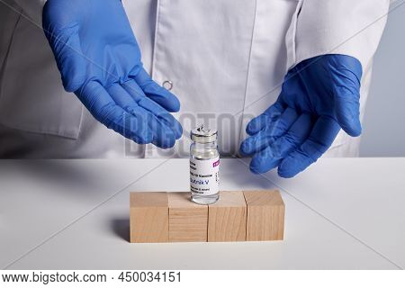 Krasnoyarsk, Russia - April 29, 2021: Doctor Shows 4 Wooden Cubes And Sputnik V Coronavirus Vaccine 