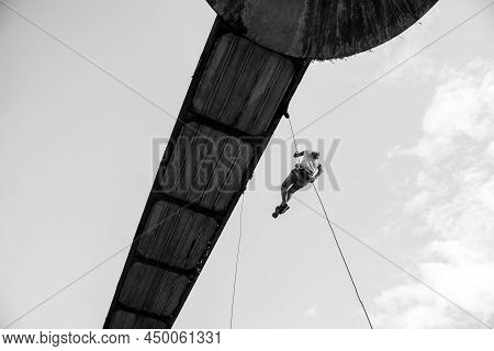 Woman Practicing Rappel On A Pedestrian Walkway.