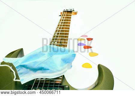 Mask, Guitar And Plectrums On A White Background