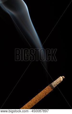 Close-up Of Burning Stick Of Incense Isolated On A Black Background.