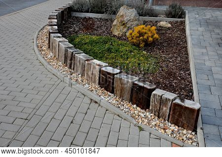 A Colorful Perennial Flowerbed At The Entrance To The Garden Bordered By A Decorative Wooden Palisad