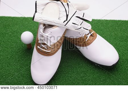 Close-up Of Golf Set, Stylish White Leather Boots With Brown Golf Inserts, Ball And Gloves. Special 