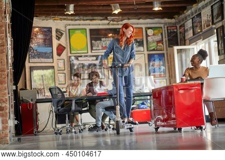 Young coworkers reaxing together at the office; Casual workspace concept