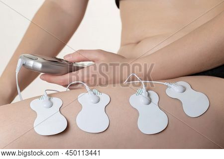 Electrodes Of Modern Acupuncture And Anti-cellulite Massagers On The Legs Of A Girl In Problem Areas