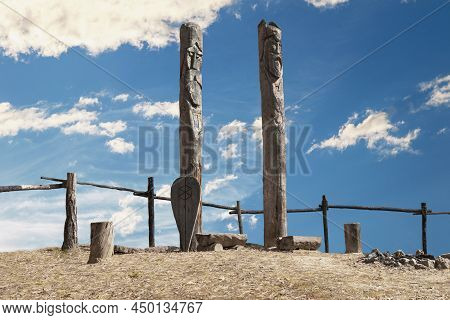Northern Lands. A Pagan Temple In The Taiga With Two Wooden Idols. The Image Of Pagan Gods Is Carved