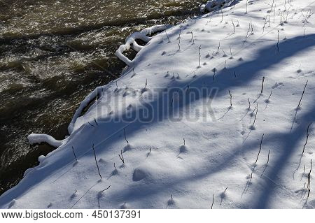 A Fresh Coating Of Snow On The Forest Floor Next To The Flowing Waters Of Hammel Creek, Creates A St