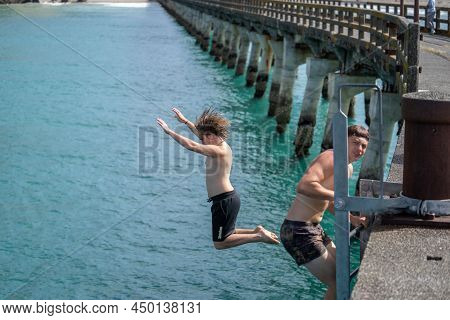 Tolaga Bay New Zealand - February 5 2022; Local Boys Jumping Of Tolaga Bay Wharf