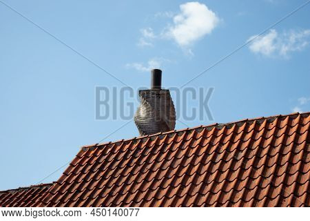 Chimney On The Roof Of An Old Houses. Tiled Roof And Blue Sky. Heating Systen.