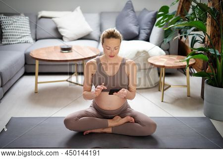 Pregnancy And Technoloy Supported Healthy Lifestyle Concept. Cheerful Happy Pregnant Woman Using Sma