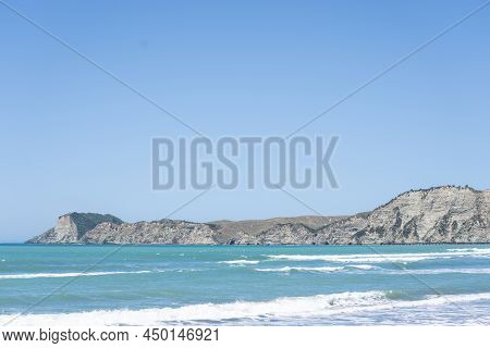 Weathered White Cliff Beyond Water At Tolaga Bay, New Zealand.