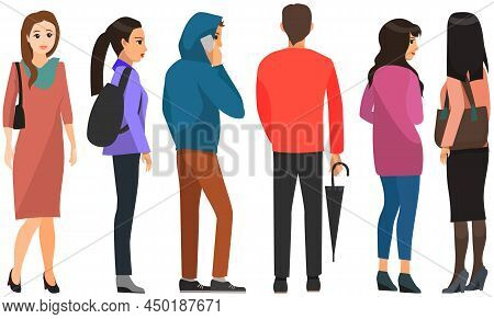 Backview Of People Looking At Something. Men And Women In Different Clothes Stand With Their Backs T