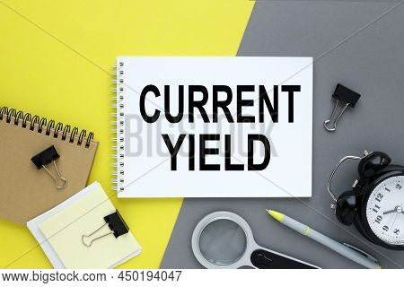 Current Yield Gray And Yellow Background With Notepad. Text On White Paper
