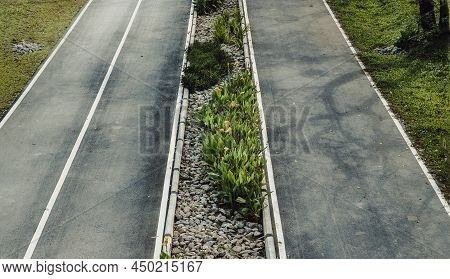Top View Of Empty Road Texture With Median Strip In The Middle Surrounded Green Grass. Selective Foc