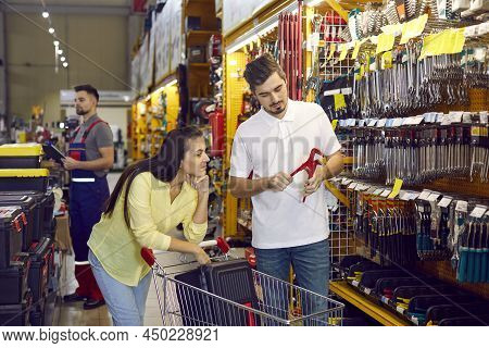 Young Couple With A Trolley Shopping For Tools At A Diy Store Or Hardware Shopping Mall