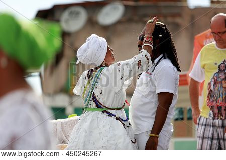Salvador, Bahia, Brazil - January 25, 2015: Candomble Adept Receives A Spiritual Bath From A Prieste