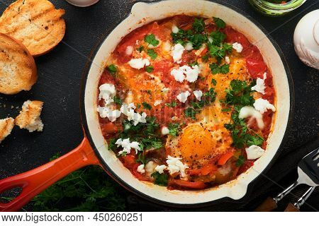Shakshuka. Homemade Fried Eggs With Vegetables In Iron Frying Pan On Old Dark Slate, Stone Or Concre
