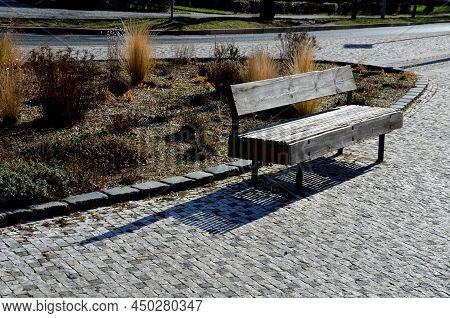 Perennial Bed Mulched With Gray Gravel In Front Of A Limestone Stone Wall In A Square With Benches W