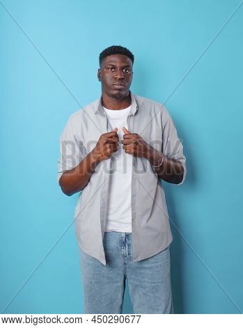 An African-american Man In White Clothes Stands On An Isolated Blue Background