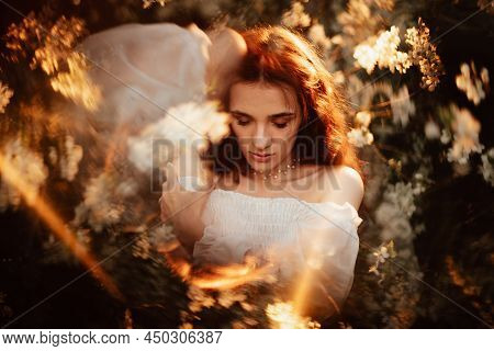 Portrait Of A Romantic Girl, Like A Forest Nymph, In A Blooming Garden With Elements Of Phantasmagor