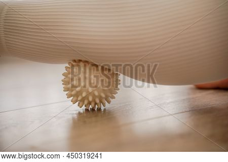 Athletic Slim Caucasian Woman Doing Thigh Self-massage With A Massage Ball Indoors. Self-isolating M