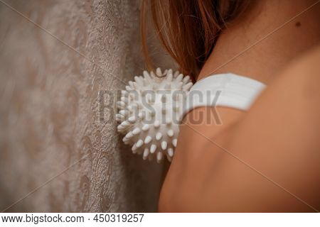 Athletic Slim Caucasian Woman Doing Thigh Self-massage With A Massage Ball Indoors. Self-isolating M