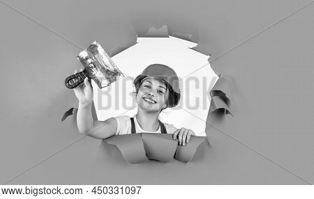 Cheerful Kid Repair Wall With Spackling Paste. Home Renovation. Kid With Tool. Happy Small Construct