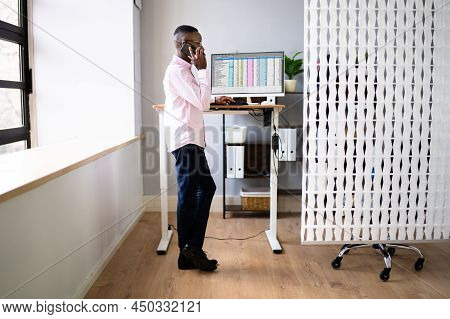 Adjustable Height Desk Stand In Office Using Computer