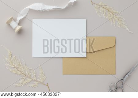 Blank Greeting Card Invitation Mockup 5x7 On Brown Envelope With Dried Flowers On Beige Background, 