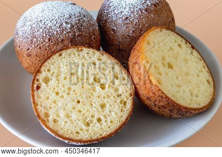 Top View Of A Plate Of Lithuanian Large Cones With One Cut, Light Brown Background Up Close