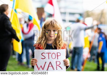 Portrait Of Child Boy Calls To Stop War In Ukraine, Holding A Poster With Stop The War Message Stand