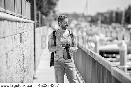 Man Hold Camera Standing On Promenade. Vacation Photography. Travel Photography