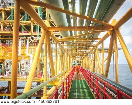 Rear View Unidentified Engineers Walking Along The Corridor At An Offshore Platform In The South Of