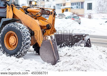 Big Orange Tractor Cleans Up Snow From The Road And Loads It Into The Truck. Cleaning And Cleaning O