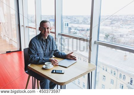 Happy Man With Coffee Calling Via Smartphone While Remote Working Laptop At Work Desk, Cheerful Free