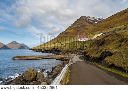 A Small Port On The Island Of Kunoy. Steep Coast And Kunoy Church In The Background. Kunoy, Faroe Is