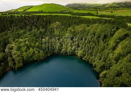 Drone View Of Congro Lake With Blue Water Surrounded By Lush Green Woods In Mountains On San Miguel