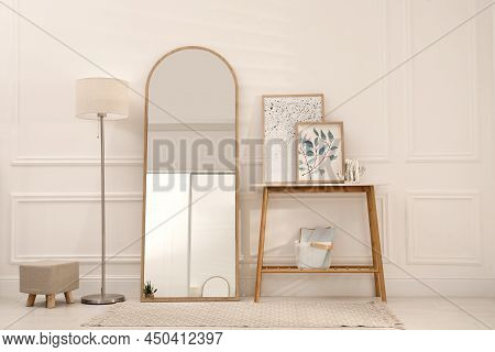 Beautiful Mirror, Console Table And Lamp Near White Wall Indoors. Interior Design