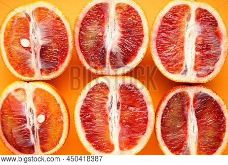 Halves Of Blood Oranges On A Orange Background, Close-up. Top View.