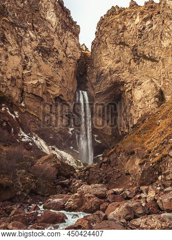 Rocky Highlands With A Waterfall Flowing Into The Gorge. The Majestic Nature Of The Caucasus