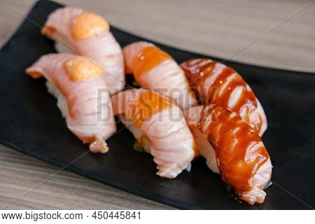 Set Of Salmon Aburi Sushi With Sauce On Plate