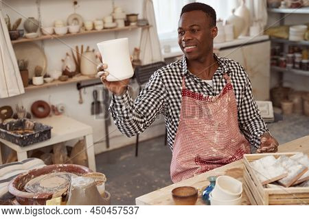 Pleased Craftsman Admiring His Unglazed Earthenware Cup